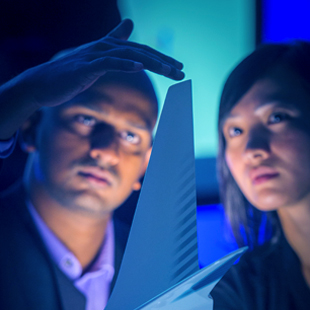 Two workers looking at a model of an airplane